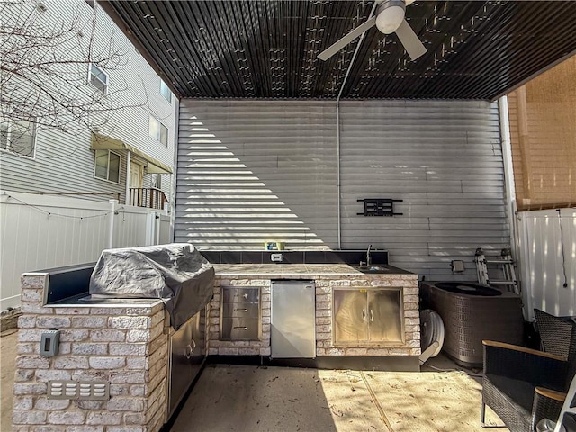 view of patio with exterior kitchen, fence, ceiling fan, and a sink