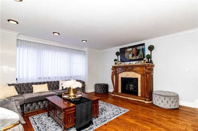 living area featuring ornamental molding, wood finished floors, recessed lighting, a fireplace, and baseboards