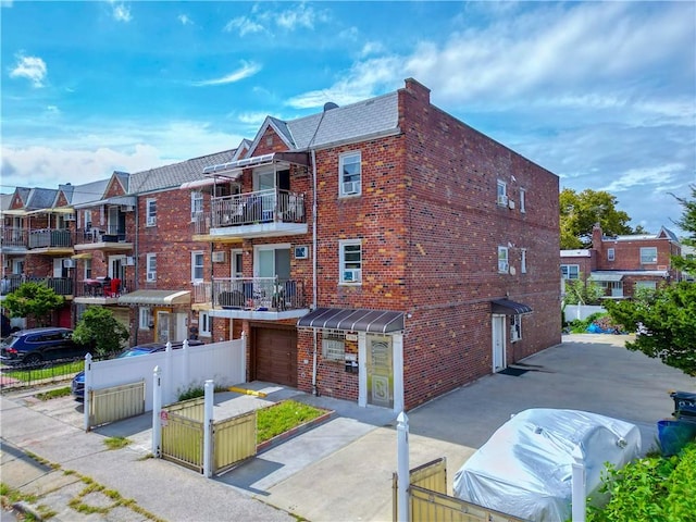 8784 24th Ave, Brooklyn, NY 11214 - exterior space featuring brick siding, driveway, a garage, and fence