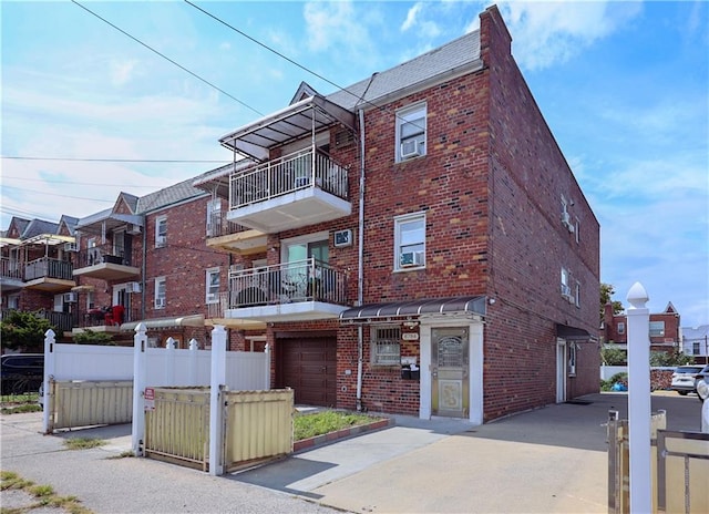 view of front of house featuring brick siding and fence