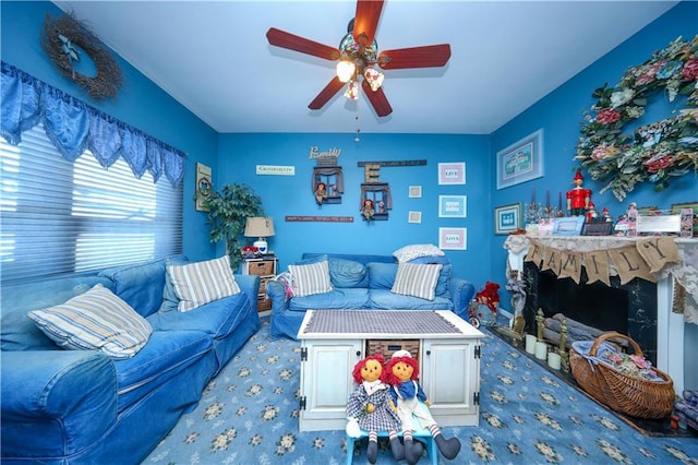 carpeted living room with a fireplace and ceiling fan