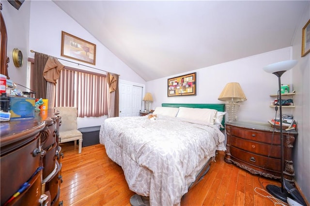 bedroom with lofted ceiling, hardwood / wood-style flooring, and a closet