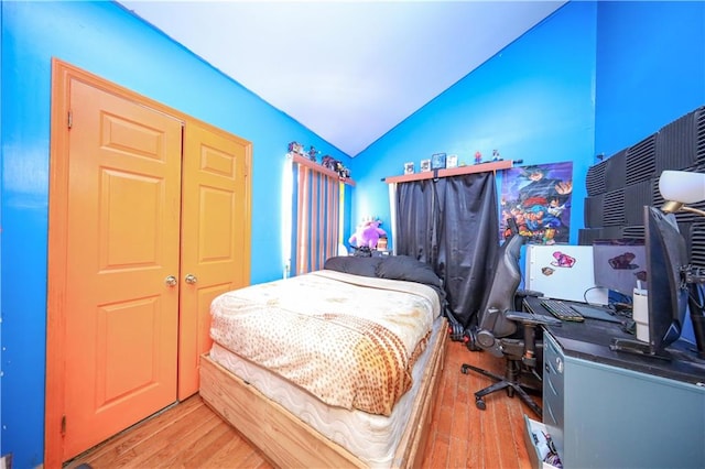 bedroom featuring lofted ceiling and light wood-type flooring