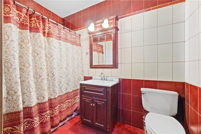 full bath featuring a shower with shower curtain, toilet, tile walls, and vanity