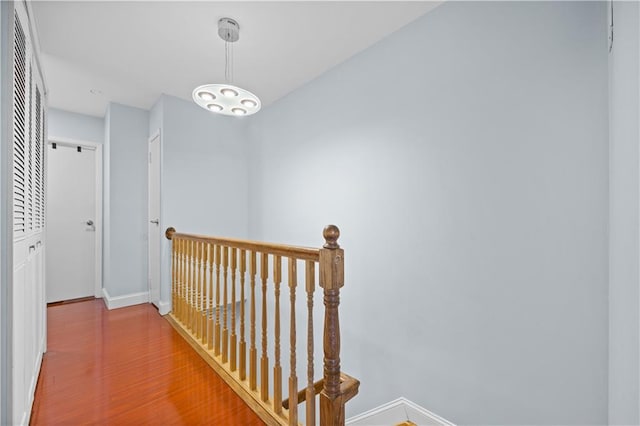 hall with baseboards and wood finished floors