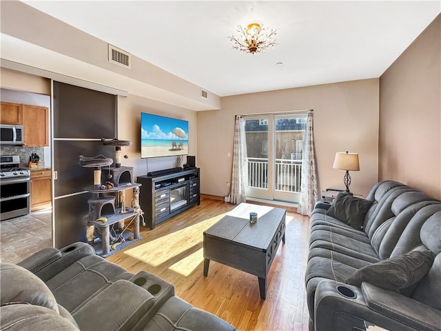 living area featuring visible vents and light wood-type flooring