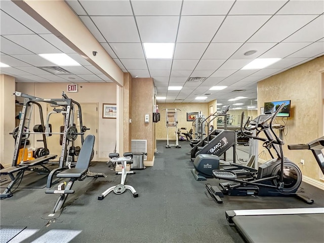 workout area featuring visible vents, baseboards, and a drop ceiling