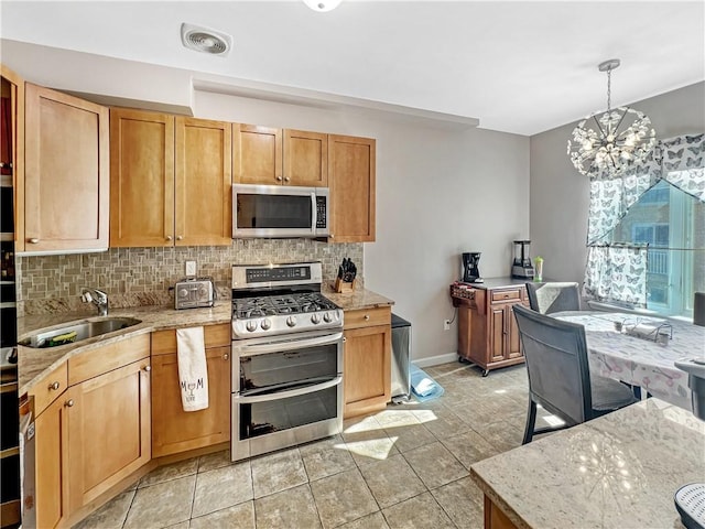 kitchen featuring backsplash, visible vents, appliances with stainless steel finishes, and a sink