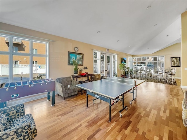 game room featuring french doors, light wood-style flooring, and vaulted ceiling