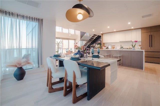 kitchen featuring modern cabinets, recessed lighting, light wood finished floors, light countertops, and hanging light fixtures