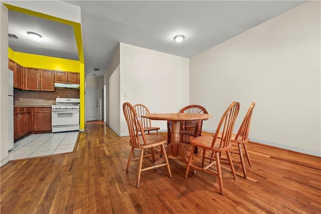 dining room featuring visible vents, light wood-style flooring, and baseboards