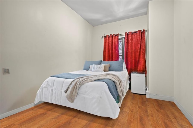 bedroom with wood finished floors and baseboards