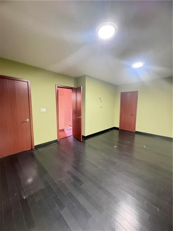 interior space featuring baseboards and dark wood-style flooring