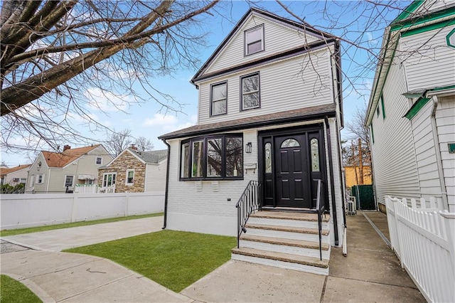 view of front of property with brick siding and fence