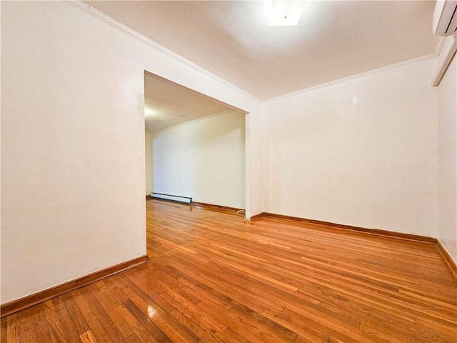 spare room with crown molding, hardwood / wood-style flooring, a wall mounted air conditioner, baseboards, and a baseboard heating unit