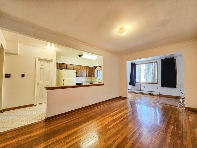 unfurnished living room with crown molding, baseboards, light wood-type flooring, and a baseboard radiator