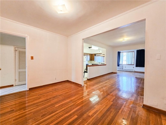 unfurnished room with baseboards, ornamental molding, and wood finished floors