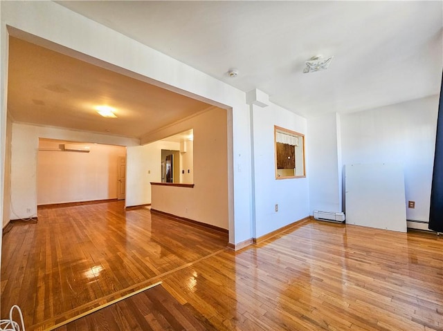 interior space with baseboards, a baseboard radiator, and hardwood / wood-style flooring
