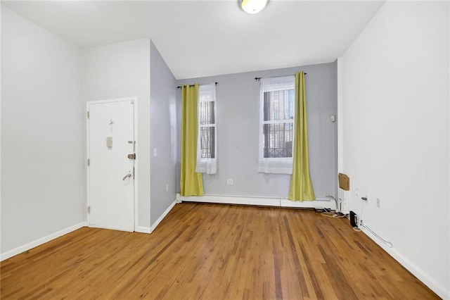 unfurnished room featuring baseboards and wood finished floors