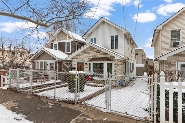 view of front of home with a fenced front yard, stone siding, and a gate