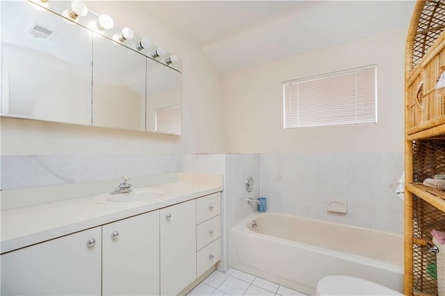 bathroom featuring vanity, a bath, visible vents, tile patterned floors, and toilet