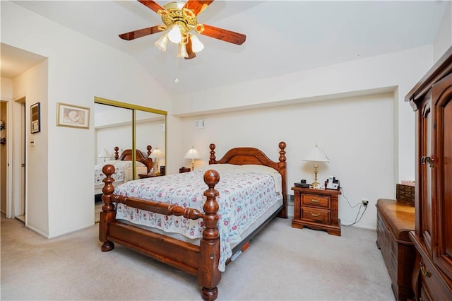 bedroom featuring a ceiling fan, lofted ceiling, light colored carpet, and a closet