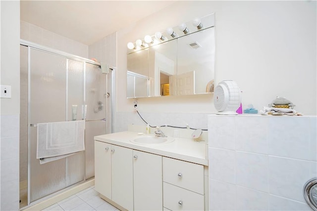 bathroom featuring tile patterned floors, visible vents, a stall shower, and vanity