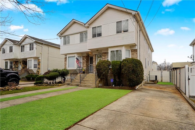 view of front of property featuring a front yard, fence, and brick siding