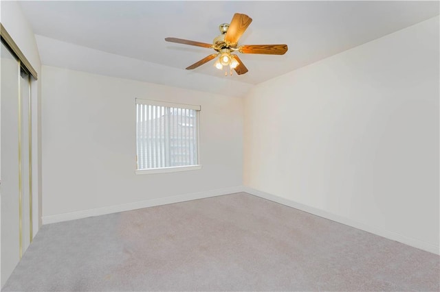 spare room with baseboards, carpet floors, lofted ceiling, and a ceiling fan