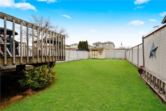 view of yard featuring an outbuilding, a fenced backyard, and a shed