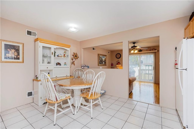 dining space with light tile patterned flooring, visible vents, and built in features