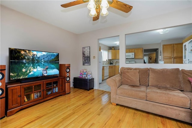 living area with light wood-type flooring and ceiling fan