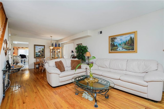 living room with visible vents and light wood-type flooring