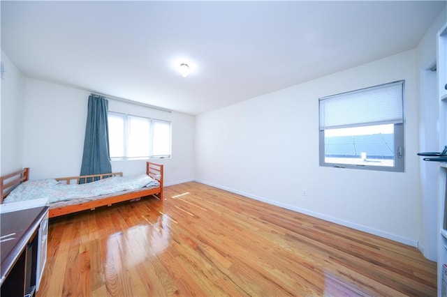 unfurnished bedroom featuring light wood-type flooring and baseboards