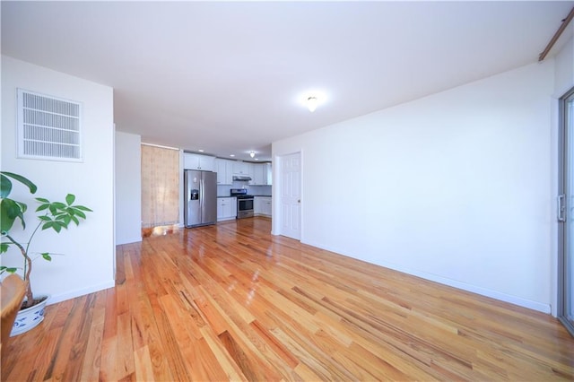 living area featuring light wood-type flooring, baseboards, and visible vents