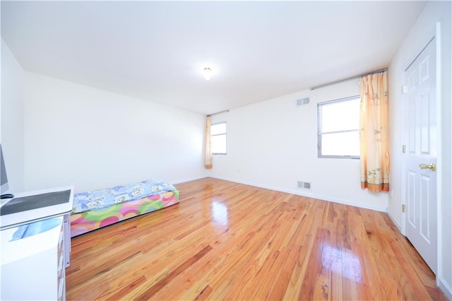 unfurnished bedroom with visible vents, baseboards, and light wood-style floors