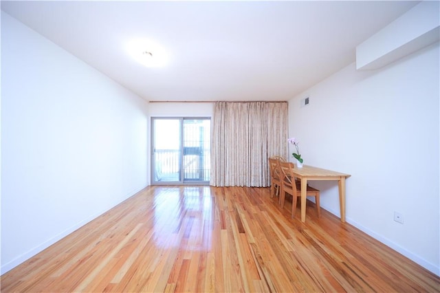 spare room featuring visible vents, light wood-type flooring, and baseboards