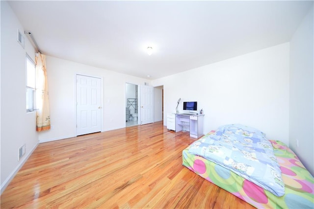 bedroom with light wood-style flooring, baseboards, and visible vents