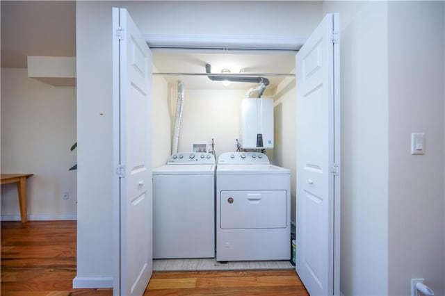 laundry area with independent washer and dryer, wood finished floors, laundry area, and water heater