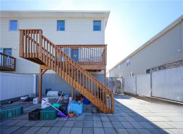 view of patio featuring stairway, a wooden deck, and fence