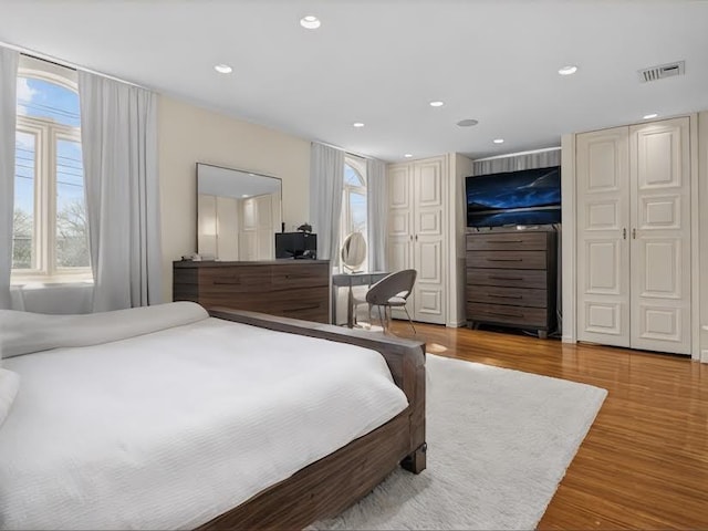 bedroom with recessed lighting, visible vents, and wood finished floors