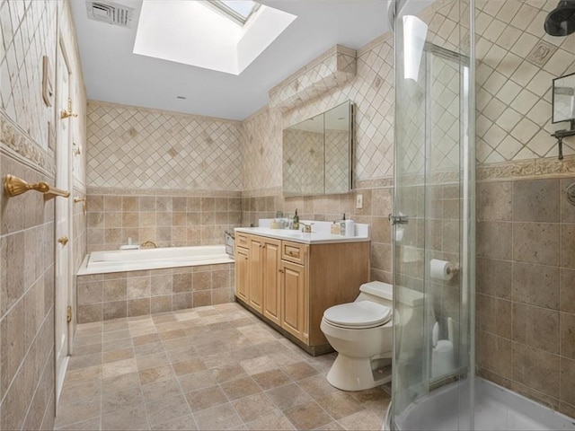 full bathroom with visible vents, a stall shower, tile walls, a skylight, and vanity