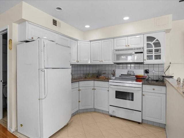 kitchen featuring visible vents, white appliances, white cabinetry, and decorative backsplash