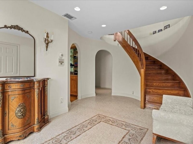 living area with visible vents, recessed lighting, arched walkways, baseboards, and stairs