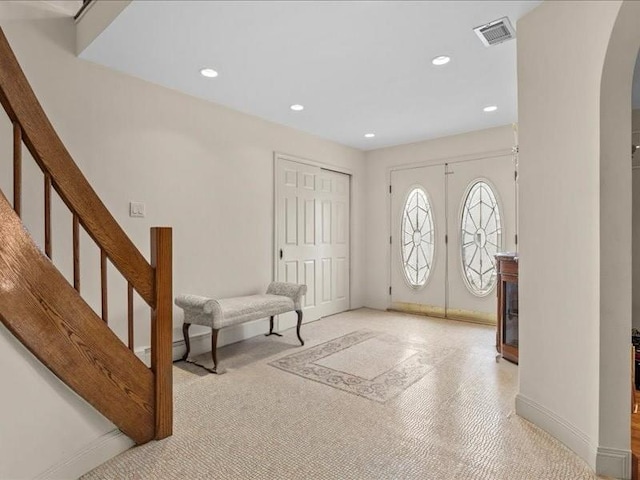 entryway featuring stairway, visible vents, recessed lighting, arched walkways, and french doors