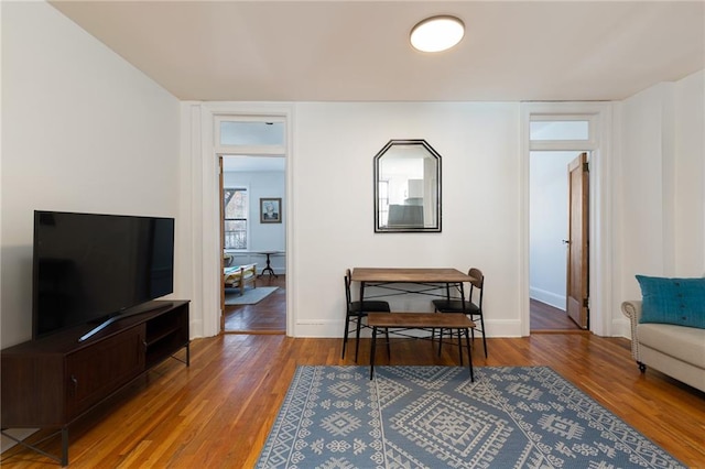 living area with baseboards and wood finished floors