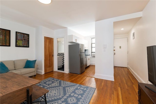 living area with baseboards and hardwood / wood-style flooring