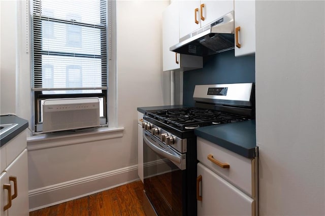 kitchen featuring white cabinetry, dark countertops, under cabinet range hood, and stainless steel gas range oven