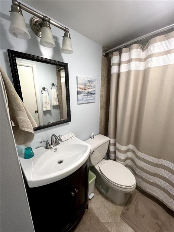 bathroom featuring vanity, toilet, and a shower with curtain