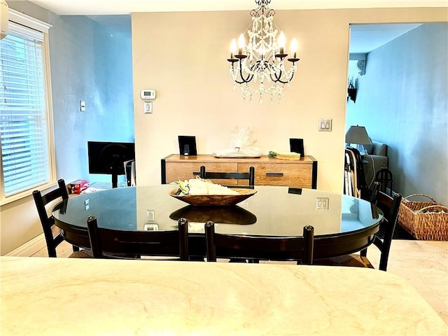 dining area with baseboards and an inviting chandelier